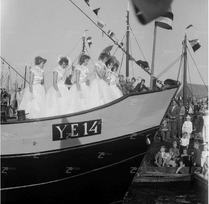 Foto: de YE-14 feestelijk versierd, met een groep in het wit geklede vrouwen aan boord